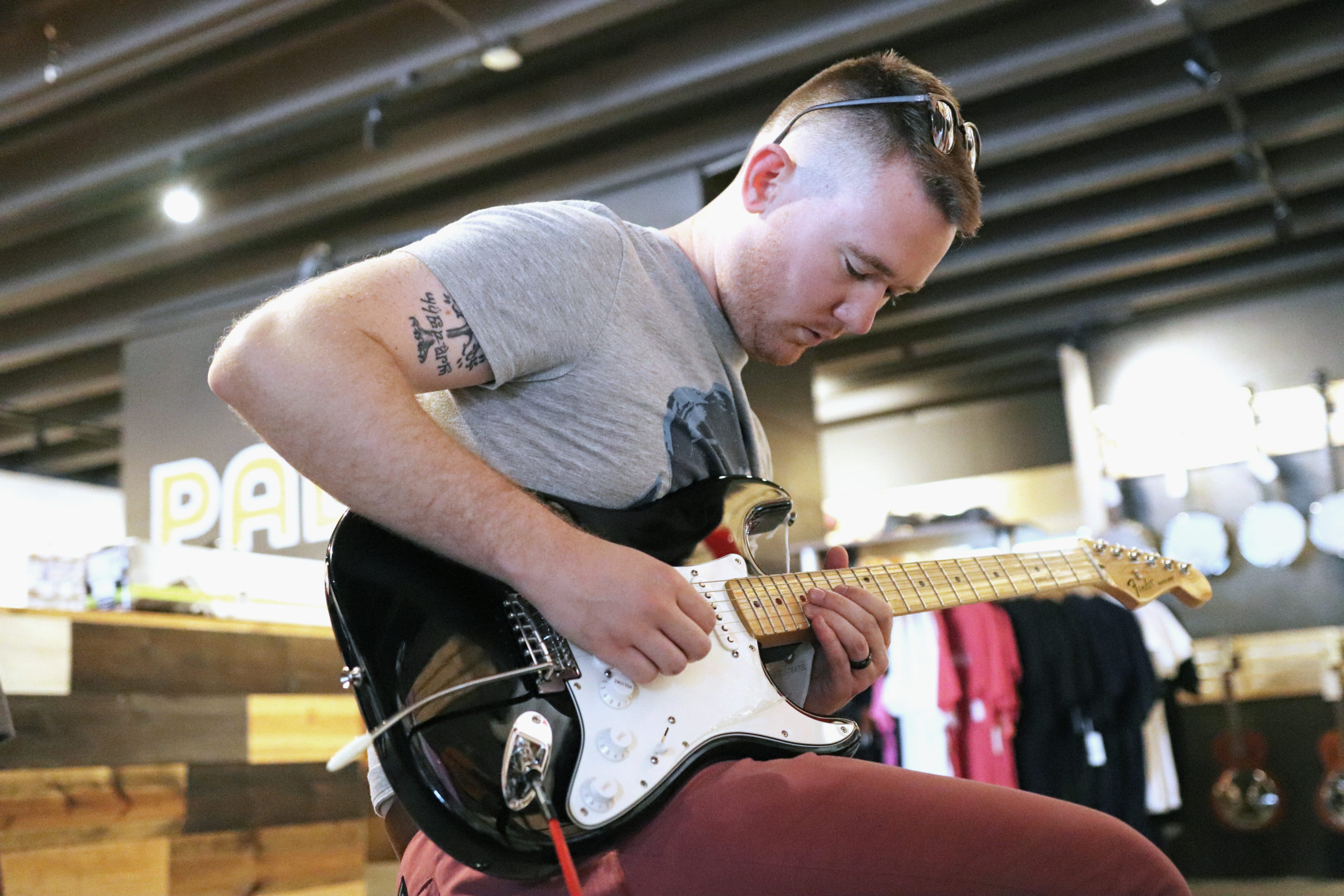 Customer-Playing-Electric A young man playing an electric guitar.